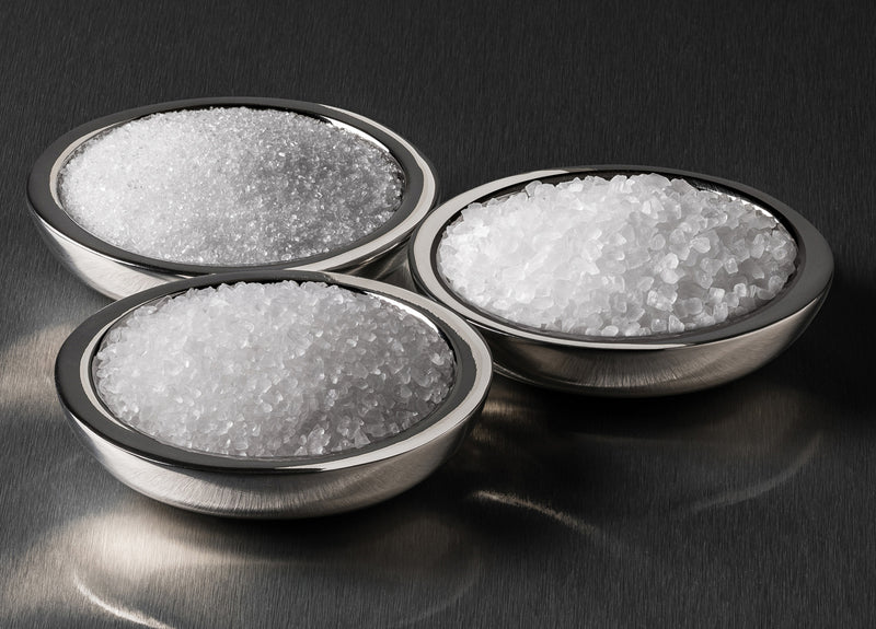 three stainless steel bowls with white salt